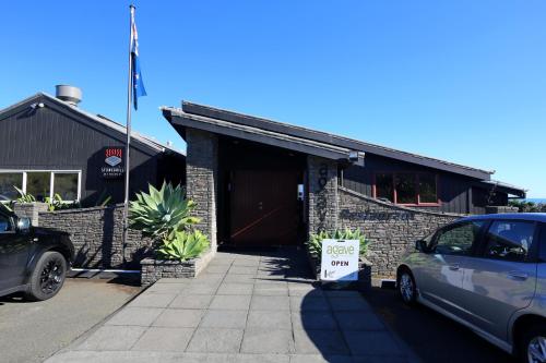 a car parked in front of a building with a speed limit sign at Waiuku Lodge Motel in Waiuku