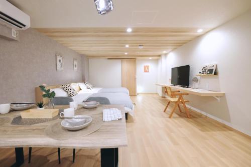 a bedroom with a bed and a table and a tv at 夢の舎上北沢 Yumenoya Kamikitazawa in Tokyo