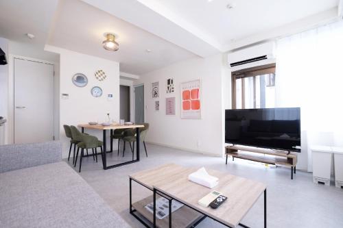 a living room with a television and a table at 夢の舎上北沢 Yumenoya Kamikitazawa in Tokyo