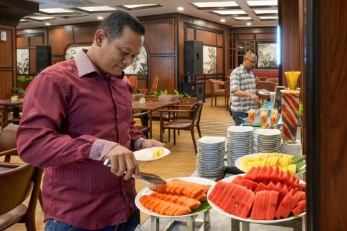 a man is preparing food in a restaurant at Hotel Pangeran in Pekanbaru
