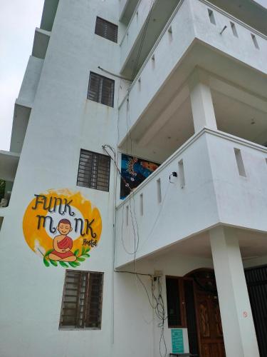 a building with a sign on the side of it at Funk Monk hostel visitors centre auroville in Auroville