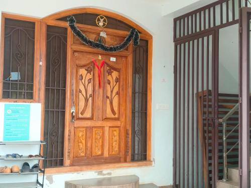 a wooden door with a red ribbon on it at Funk Monk hostel visitors centre auroville in Auroville