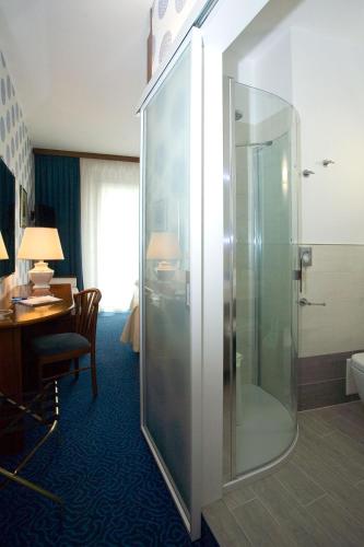 a bathroom with a shower in a hotel room at Hotel Corallo in Bibione