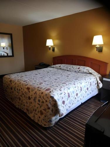 a large bed in a hotel room with two lamps at Rodeway Inn Mount Laurel Hwy 73 in Mount Laurel