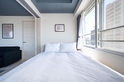 a large white bed in a room with a window at Hills Garden 405 in Sapporo