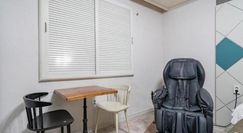 a table and chairs in a room with a table and a chair at Luxury Motel Daejeon in Daejeon