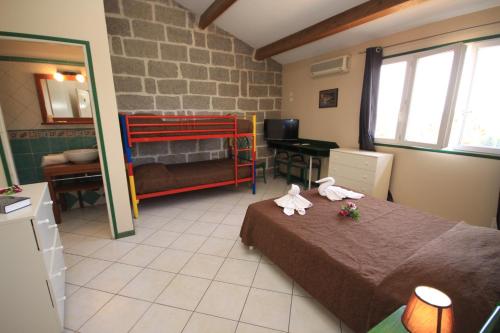 a small room with a bed and a bedroom with a bedictericter at Hotel Clair de Lune in Zonza