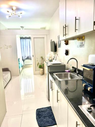 a kitchen with a sink and a counter top at Dvine Era Staycation in Manila