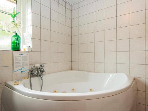 a bath tub in a bathroom with white tiles at Luxury Seaside Retreat - By Traum Ferienwohnungen in Fjand Gårde