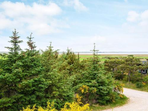 a dirt road through a field with trees at Luxury Seaside Retreat - By Traum Ferienwohnungen in Fjand Gårde