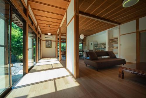 a living room with a couch and a table at ISHIZUCHI Villa HANA in Saijo