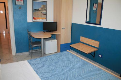 a room with a desk and a bed with a computer at B&B Brezza Marina & Ristorante Shoreline in Pozzallo