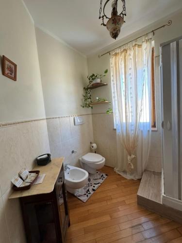 a bathroom with a toilet and a sink and a window at Villa Radiosa in Gravina in Puglia