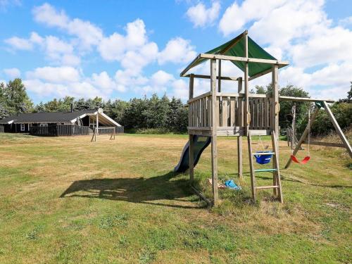 a playground with a swing set in a field at 9 person holiday home in Jerup in Jerup