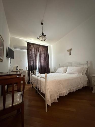 a bedroom with a white bed and a window at Villa Radiosa in Gravina in Puglia