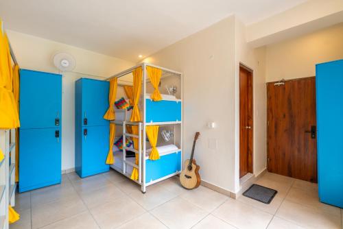a room with blue cabinets and a guitar at goSTOPS PLUS Kasol, Suma Ropa in Kasol