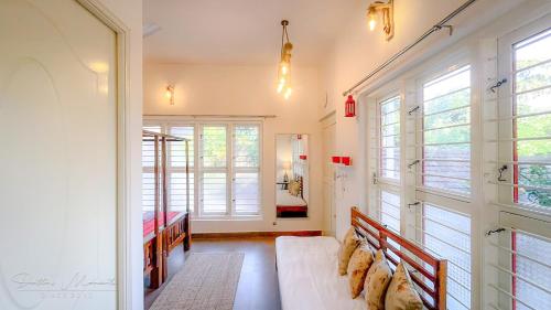 uma sala de estar com um sofá e algumas janelas em Arabica Homestay em Somvārpet