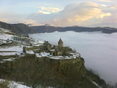 a castle on top of a mountain in the snow at Bed and Breakfast John and Lena in Tatʼev