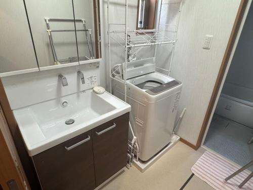 筑西市にあるOtsu Guest houseの洗面台と鏡のある小さなバスルーム