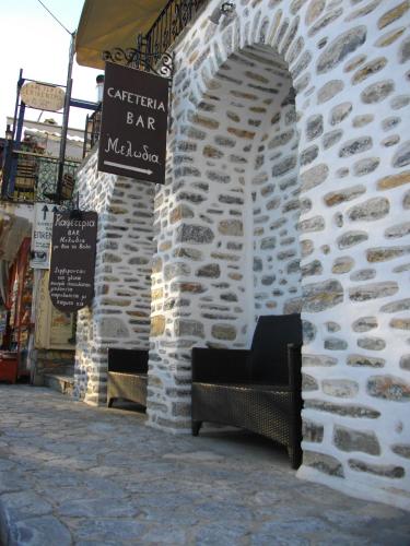 a stone wall with a bench outside of a store at Mansion Theodora in Makrinítsa