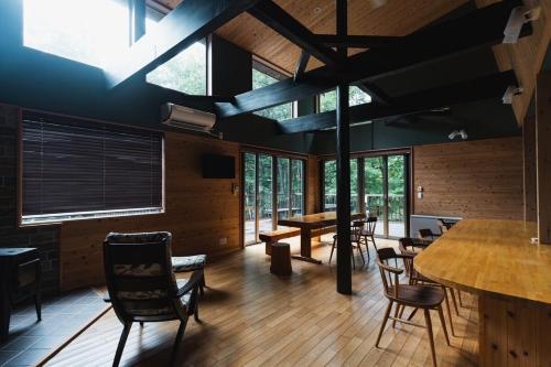 a dining room with chairs and tables and windows at Starry sky, private sauna Achi Village Villa for 10 people Luxury in nature under the best starry sky in Japan in Achi