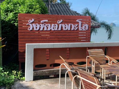 a building with chairs and a sign on it at Wanghin Bungalow in Surat Thani