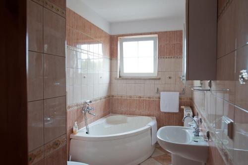 a bathroom with a tub and a toilet and a sink at Hotel Victoria in Lubowo