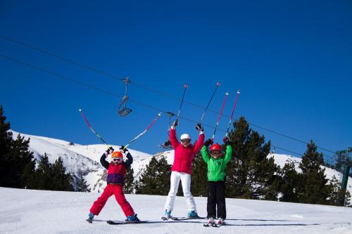 een groep van drie personen op een skilift bij Hotel Plein Soleil in Allos