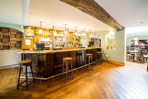 a bar in a restaurant with stools in a room at The Green Dragon in Wellington