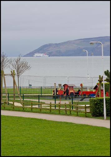 a park with a playground next to the water at Lakeview Guest House in Stranraer