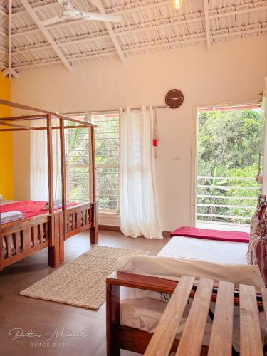 a bedroom with two beds and a large window at Arabica Homestay in Somvārpet
