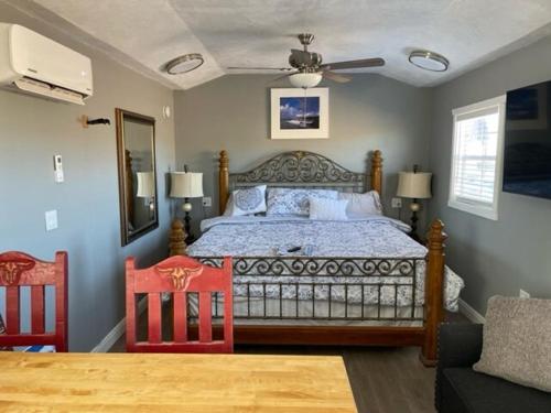 a bedroom with a bed and two red chairs at The Wild Toro The Wild West 40 Homestead in Cane Beds