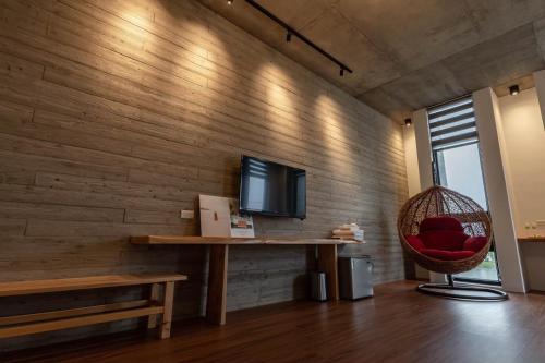 a living room with a television and a red chair at 佇沐民宿 in Xingjian