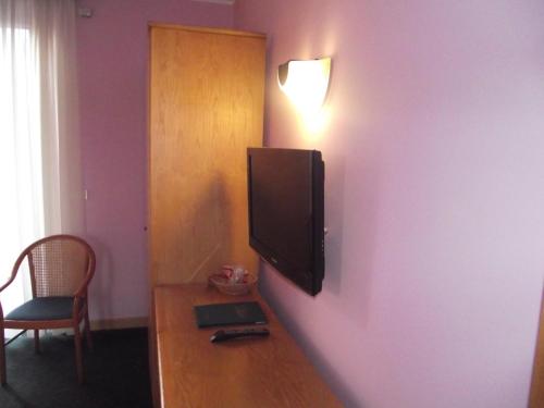 a room with a tv on a purple wall at Hotel Ristorante alla Campagna in San Giovanni Lupatoto