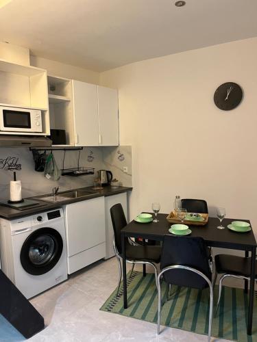 une cuisine avec une table et des chaises dans une cuisine dans l'établissement charmant duplex 5, au Havre