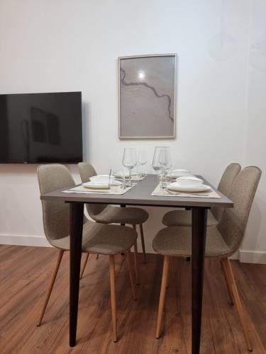 a dining room table with chairs and wine glasses at KC Apartments 3 in Berat