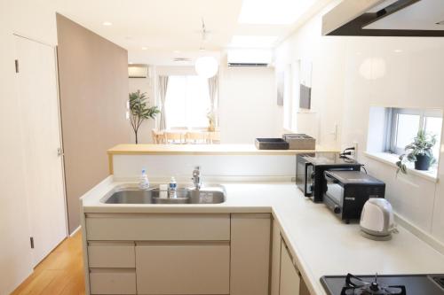 a kitchen with a sink and a microwave at Dori Dori House Shinjuku1 in Tokyo