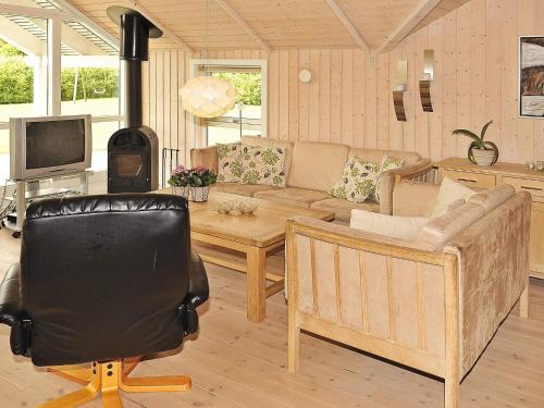 a living room with a couch and a wood stove at 4 star holiday home in Ansager in Ansager