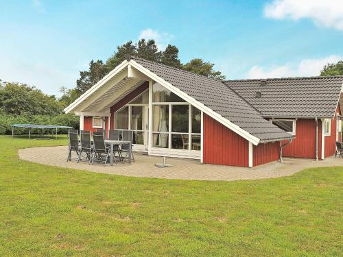 a red house with a table and chairs in front of it at 4 star holiday home in Ansager in Ansager