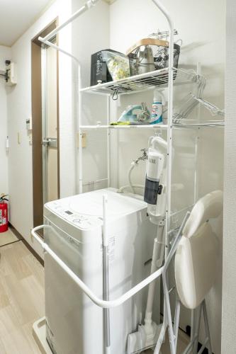 a hospital room with a washing machine and a chair at UPHouse 2C Gotokuji in Tokyo