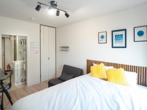 a bedroom with a large bed and a chair at UPHouse 2C Gotokuji in Tokyo