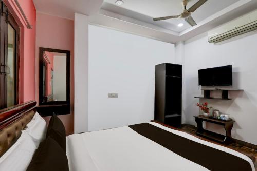 Un dormitorio con una cama y un televisor de pantalla plana. en Hotel O Heavens Inn, en Hyderabad