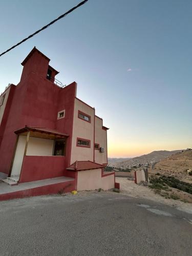 a red building sitting on the side of a road at Petra Brothers in Petra