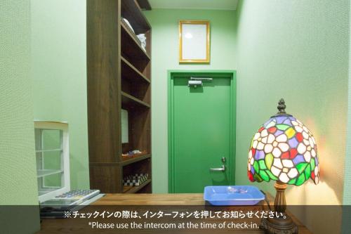 a room with a green door and a stained glass lamp at Akasaka-no Sato (Female Only) in Tokyo