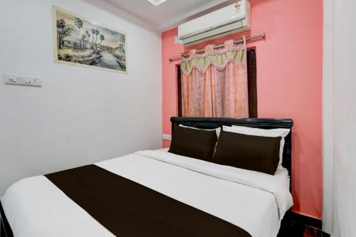 Un dormitorio con una cama con una pared roja. en Hotel O Heavens Inn, en Hyderabad