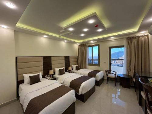 a hotel room with two beds and a desk at Petra Brothers in Petra