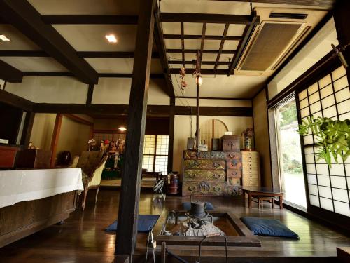 a living room with a table and some windows at Yumorinoyado Sannozyou in Mogami