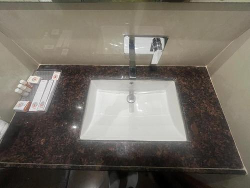 a bathroom sink with a faucet on a counter at Nirvana Grand Hotel & Resort in Gaya