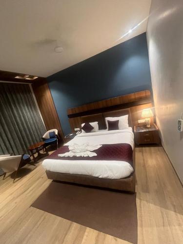 a bedroom with a large bed with a blue wall at Nirvana Grand Hotel & Resort in Gaya