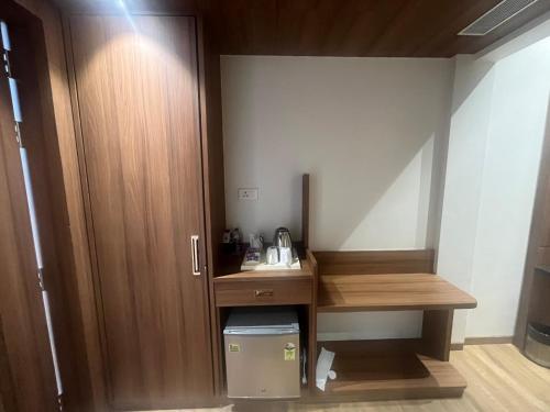 a small room with a desk and a cupboard at Nirvana Grand Hotel & Resort in Gaya